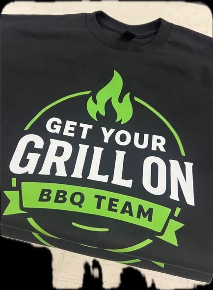 Black team shirt printed Get Your Grill On BBQ Team with a green flame
