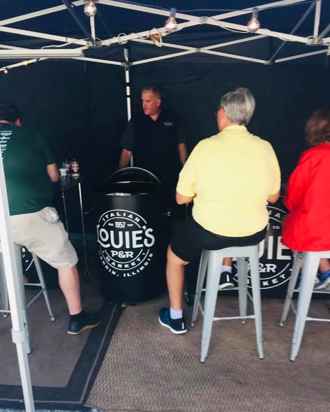The team under their tent beside a Louie's-branded smoker