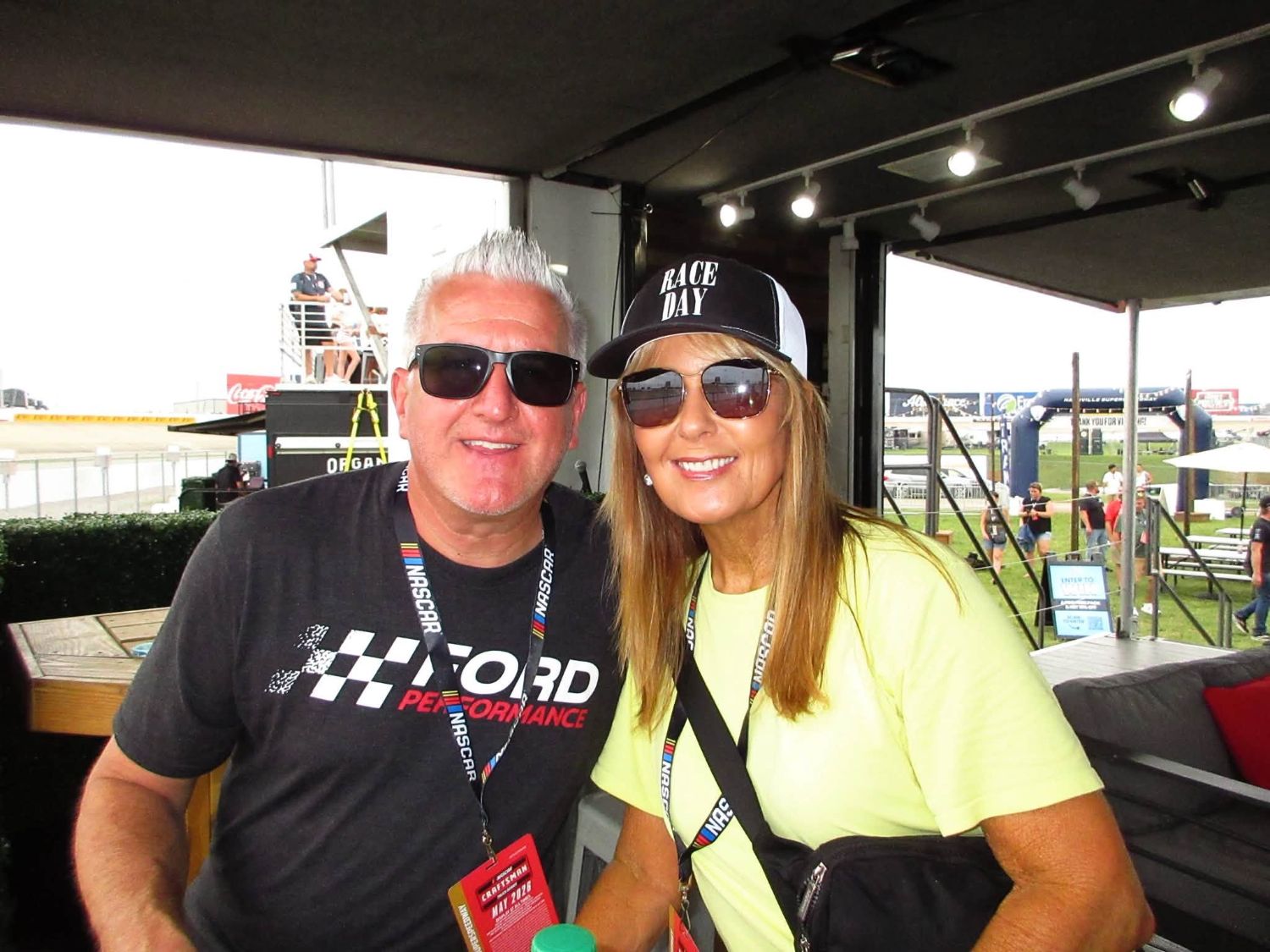 Julie and Aaron Christ smiling trackside at a NASCAR event