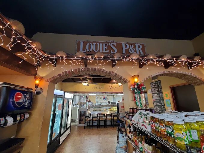 Inside Louie's P&R: brick archway, string lights, and the deli counter